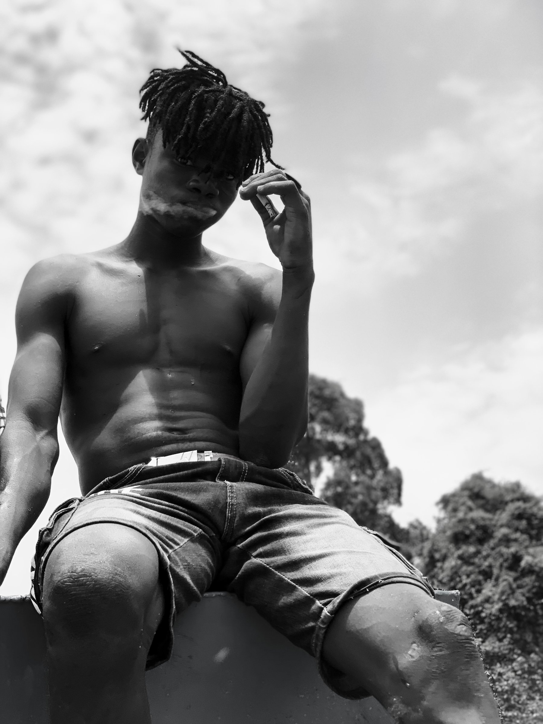 Un adolescent travaillant sur une drague libérienne prend la pose. Fleuve Bandama, Côte d'Ivoire (2024).
