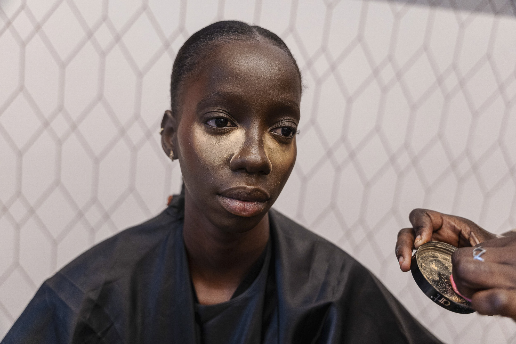 Oumy Dione, 24 ans, se fait maquiller avant le premier défilé à l'ambassade de Turquie. Dakar, 5 décembre 2024.
