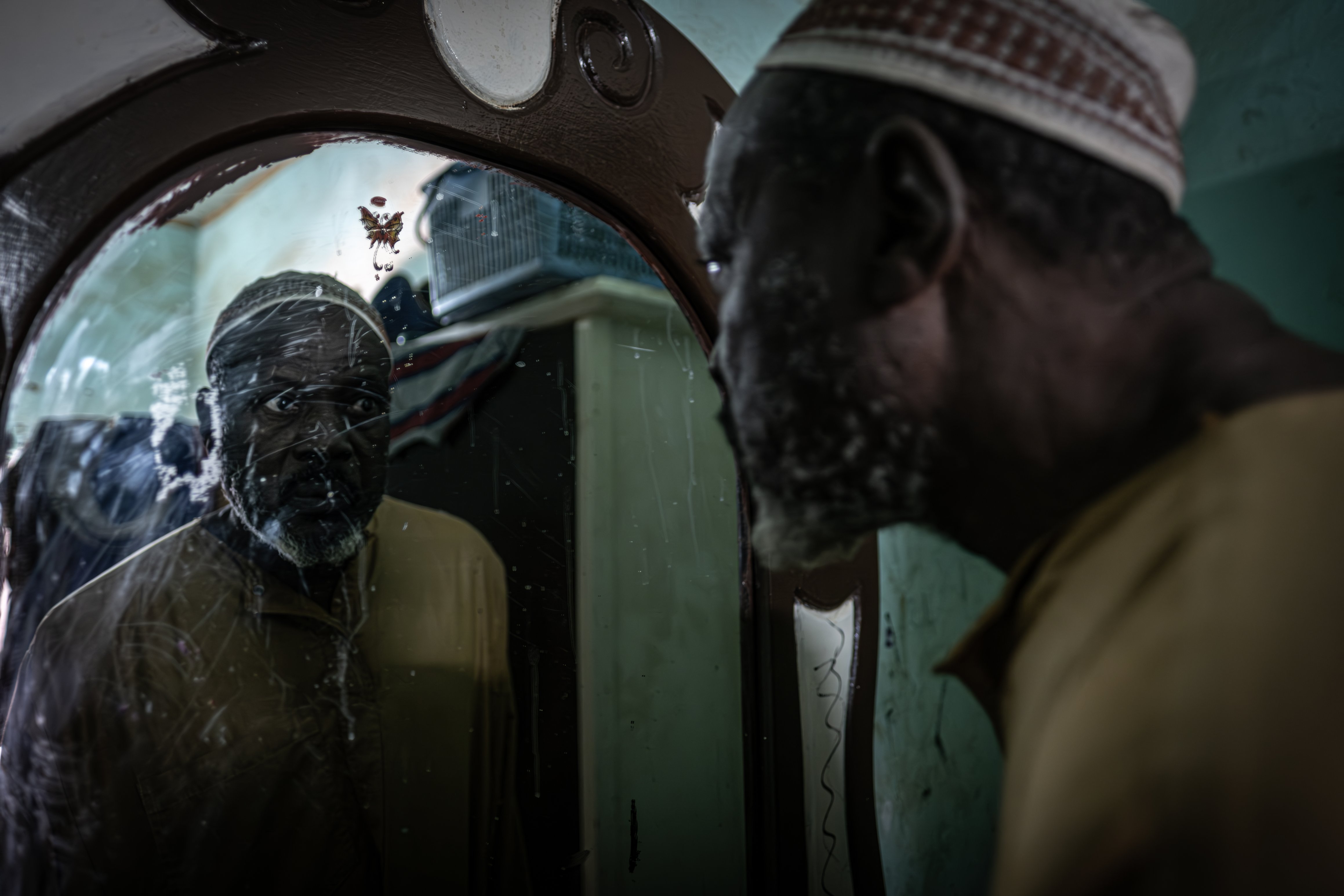 Issaka Alzouma, who worked for Cominak for over thirty-eight y years, looks at himself in the mirror in his house in Akokan. He is suffering from a number of ailments, probably including Alzheimer's disease.