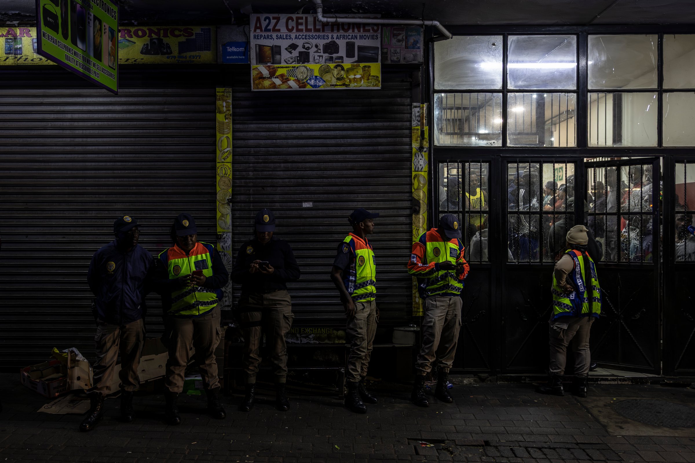 Des agents du Johannesburg Metro Police Department (JMPD) attendent à l'extérieur de l'immeuble illégalement occupé (18 décembre 2025).