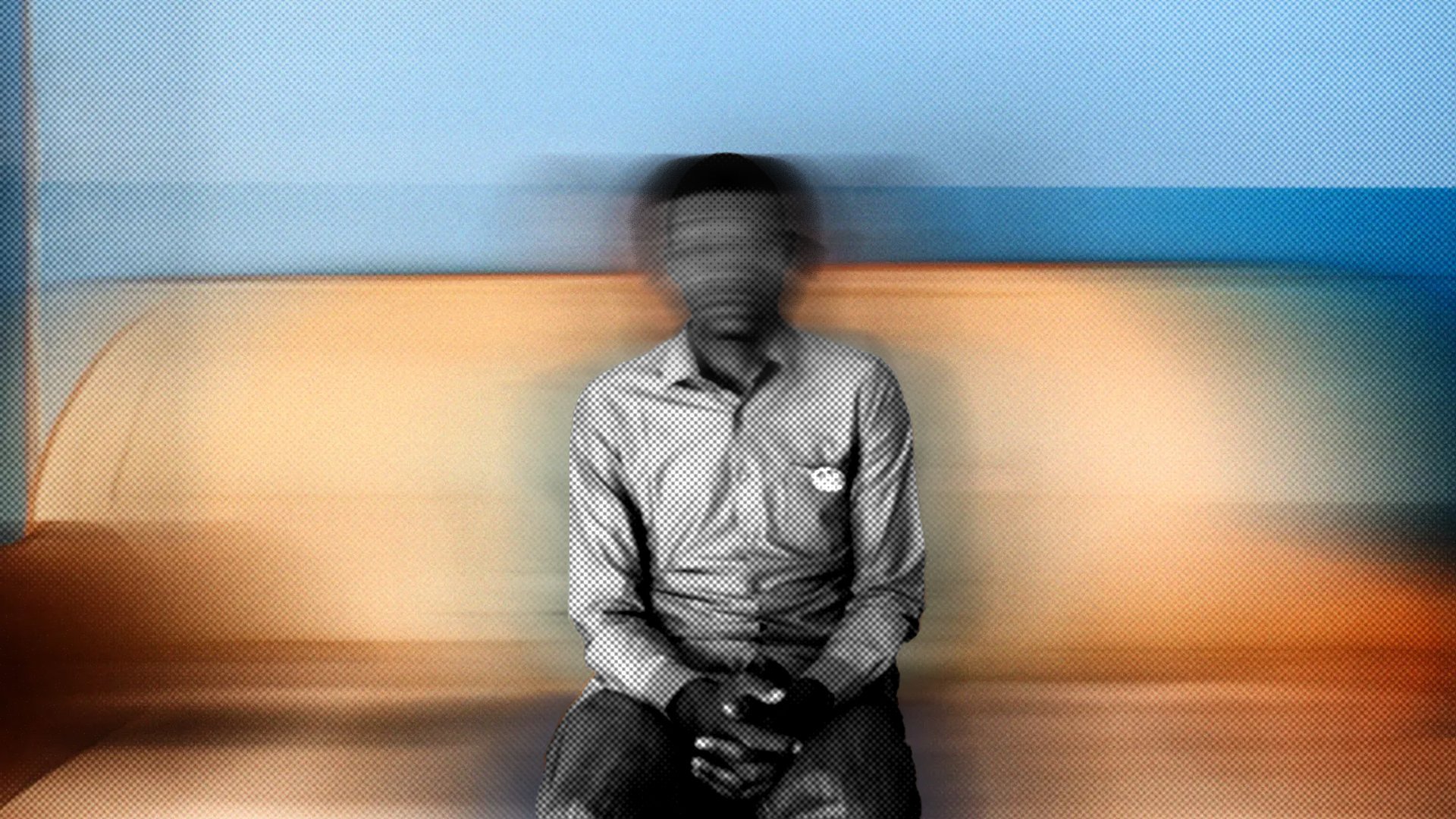 Cette image montre une personne assise sur un canapé. Le fond est flou, ce qui donne une impression de mouvement. La personne porte une chemise à rayures et a les mains posées sur ses genoux. L'atmosphère de l'image est douce grâce aux couleurs chaudes du canapé et aux nuances de bleu derrière. L'ensemble crée une sensation de calme, mais le flou ajoute une dimension de mystère.