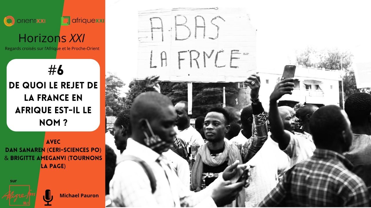 Cette image représente une scène dynamique d'un rassemblement ou d'une manifestation. Au centre, on peut voir une personne levant une pancarte où il est écrit en grands caractères "ABAS LA FRYCE". Les participants autour semblent mobilisés et engagés dans la discussion ou l'action. En arrière-plan, on aperçoit des bâtiments et une foule, ce qui donne une impression de mouvement et d'énergie collective. En bas de l'image, il y a un encart présentant le numéro de l'événement, un titre en lien avec le sujet du rejet de la France en Afrique, ainsi que des noms de participants et un logo. L'ambiance générale est celle d'une mobilisation sociale autour d'un thème important.