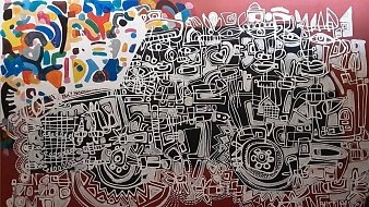 Cette image présente une œuvre d'art abstraite aux formes et motifs complexes. Le fond est d'un rouge profond, sur lequel se détachent des lignes blanches dessiné de manière ludique, créant une multitude de figures géométriques et organiques. Ces lignes forment un enchevêtrement qui pourrait évoquer un paysage urbain ou un ensemble de visages, selon l'imagination de chacun. Dans le coin supérieur gauche, des touches de couleurs vives, comme le bleu, le jaune et le vert, ajoutent une énergie dynamique à la composition. L'œuvre joue avec le contraste entre le noir, le blanc et les couleurs, attirant le regard et invitant à une exploration visuelle des détails. L'ensemble donne une impression de mouvement et de créativité, caractéristique de l'art contemporain.