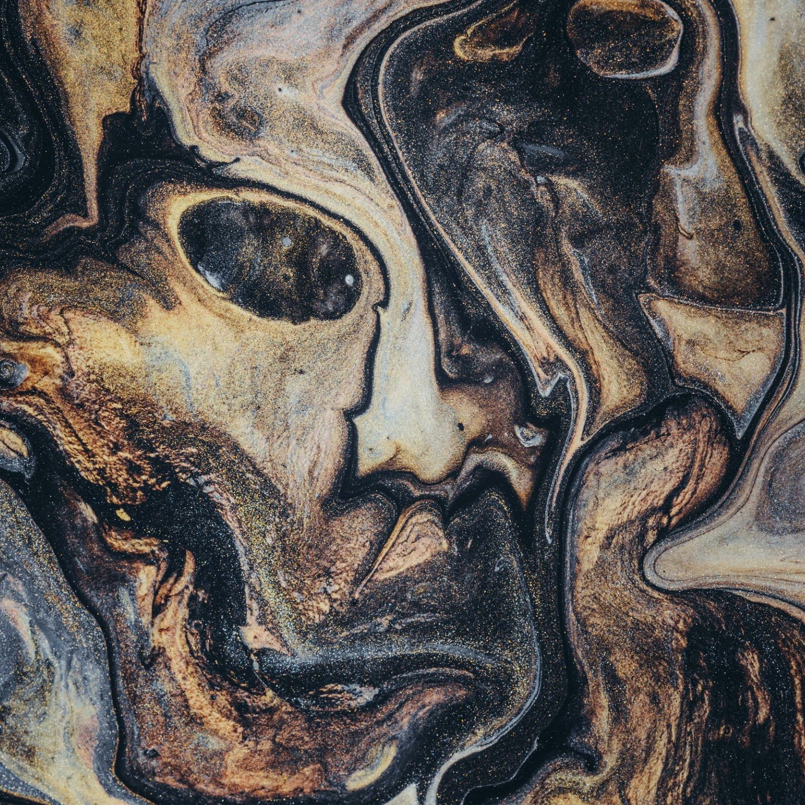 L'image présente un motif abstrait et fluide, où les couleurs noir, or et brun s'entrelacent de manière sinueuse. On peut presque percevoir des formes humaines dans ce mélange, évoquant des visages ou des silhouettes cachés dans la texture. Les lignes sont tourbillonnantes et créent une dynamique qui capte l'attention, semblant vibrer comme si elles prenaient vie. L'ensemble dégage une atmosphère mystérieuse et intrigante, invitant à l'exploration des détails et des effets de couleur.