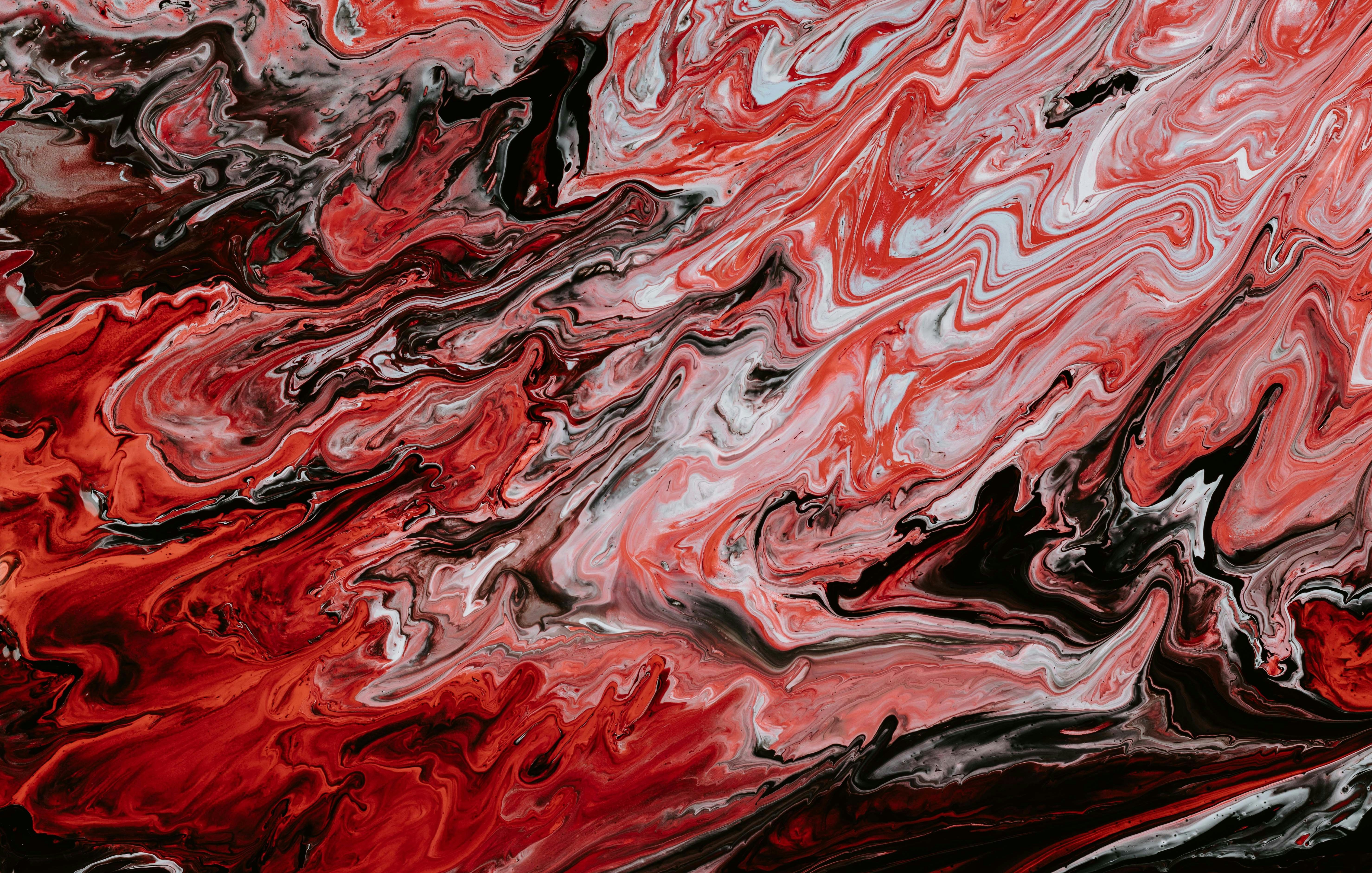 Cette image présente un motif abstrait avec des tourbillons de rouge, noir et blanc. Les couleurs se mélangent de manière fluide, créant une sensation de mouvement et d'énergie. Le rouge prédomine, évoquant des émotions intenses, tandis que le noir apporte une profondeur et un contraste. Les ondulations et les courbes suggèrent un dynamisme, presque comme une danse de couleurs qui se chevauchent et s'entrelacent. L'ensemble évoque une atmosphère à la fois passionnée et mystérieuse.