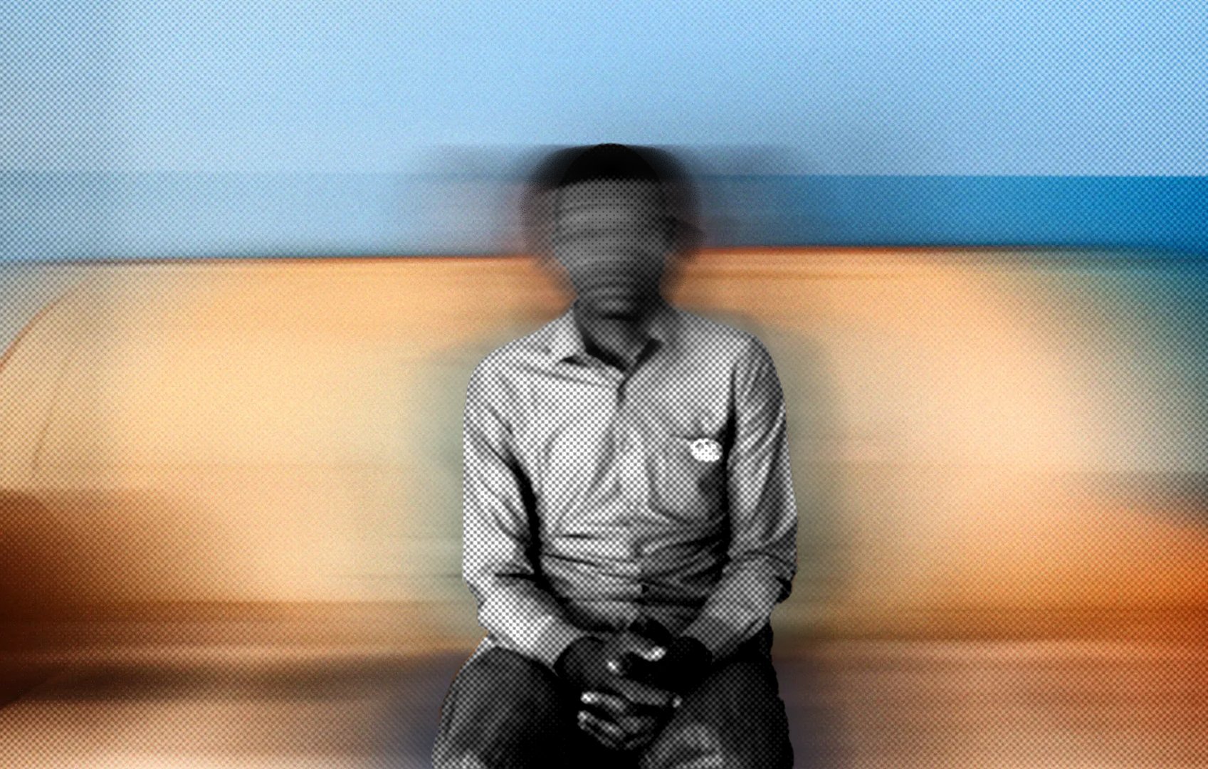 Cette image montre une personne assise sur un canapé. Le fond est flou, ce qui donne une impression de mouvement. La personne porte une chemise à rayures et a les mains posées sur ses genoux. L'atmosphère de l'image est douce grâce aux couleurs chaudes du canapé et aux nuances de bleu derrière. L'ensemble crée une sensation de calme, mais le flou ajoute une dimension de mystère.