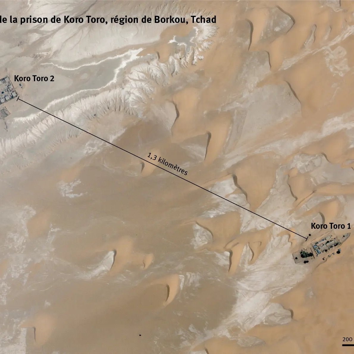 Cette image est une carte satellite des deux sites de la prison de Koro Toro, situés dans la région de Borkou au Tchad. On voit une étendue désertique avec des dunes de sable clair et des zones rocheuses. Les deux complexes de la prison, désignés comme Koro Toro 1 et Koro Toro 2, sont indiqués par des marqueurs. Koro Toro 2 est situé à l'ouest, tandis que Koro Toro 1 se trouve à l'est, séparés par une distance d'environ 1,3 kilomètre. En bas de l'image, il y a une échelle qui montre que la distance totale est de 200 mètres, et une orientation indiquant le nord. L'image a été prise le 4 mai 2023.