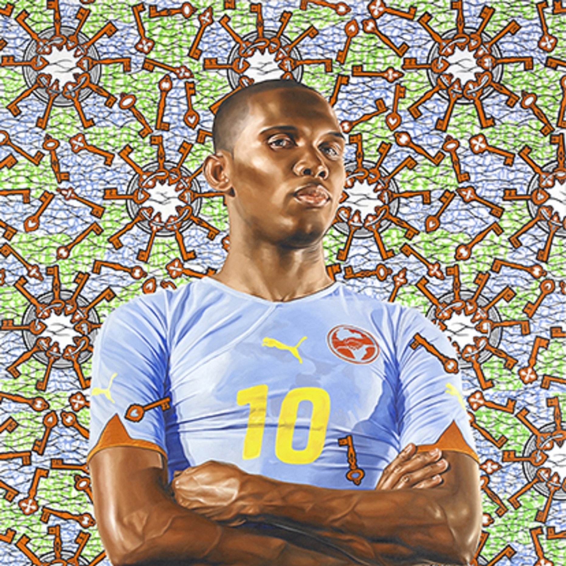 L'image représente un joueur de football en pleine posture, avec les bras croisés. Il porte un maillot bleu clair avec le numéro 10 en jaune, et un short orange. Son expression est déterminée et confiante. En arrière-plan, il y a un motif vibrant et coloré, avec une texture qui évoque des éléments de jeu, tels que des clés et des formes géométriques, créant une atmosphère dynamique autour du joueur. L'ensemble de la scène transmet une impression de force et de passion pour le sport.