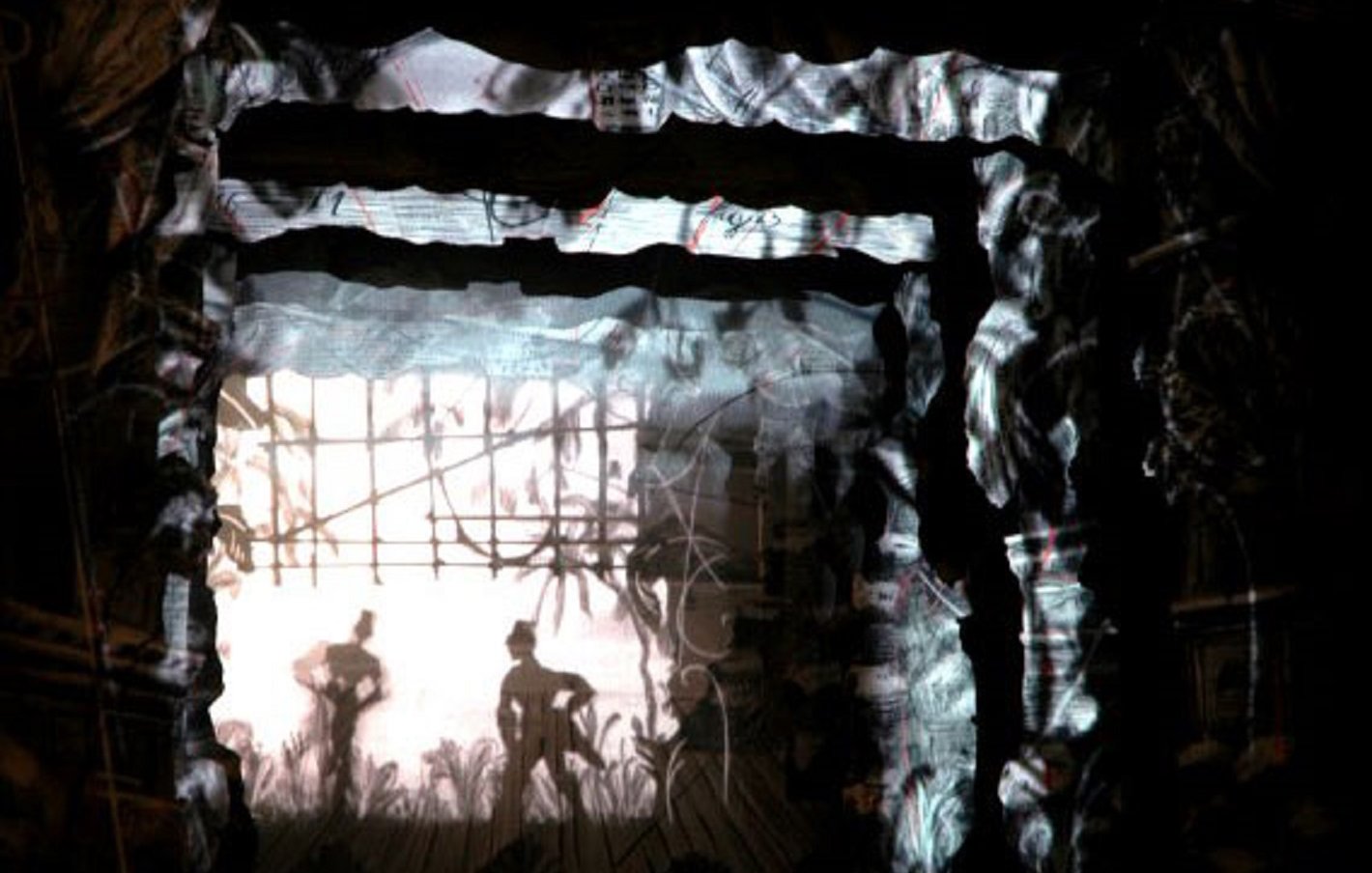 Imaginez une scène immersive où l'obscurité cède lentement la place à des formes délicates et intrigantes. Vous vous trouvez dans un espace structuré, semblable à un tunnel, dont les murs sont texturés, évoquant un rocher ou un vieux bois. Sur ces murs, des projections lumineuses créent des ombres dansantes, représentant des silhouettes de personnages en mouvement. Ces figures semblent interagir avec leur environnement, donnant vie à un récit visuel. Derrière ces silhouettes, on perçoit des éléments naturels, tels que des plantes ou des herbes, ajoutant une dimension organique à l'ensemble. L'atmosphère est à la fois mystérieuse et poétique, invitant à explorer les détails auditifs et tactiles qui pourraient compléter cette expérience. Vous pouvez presque sentir l'air ou l'humidité de l'espace, comme si vous étiez immergé dans un monde chargé de sensations et d'émotions.