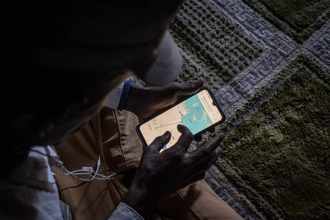 Ousmane, un Guinéen de 25 ans, montre la distance entre Agadez et Tripoli, en Libye. La traversée du désert est l'une des plus dangereuses au monde.