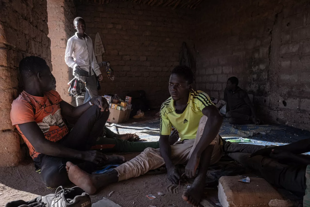 Un groupe de jeunes migrants attend de partir dans un garage où des camionnettes sont préparées dans les environs de la gare centrale d'Agadez.
