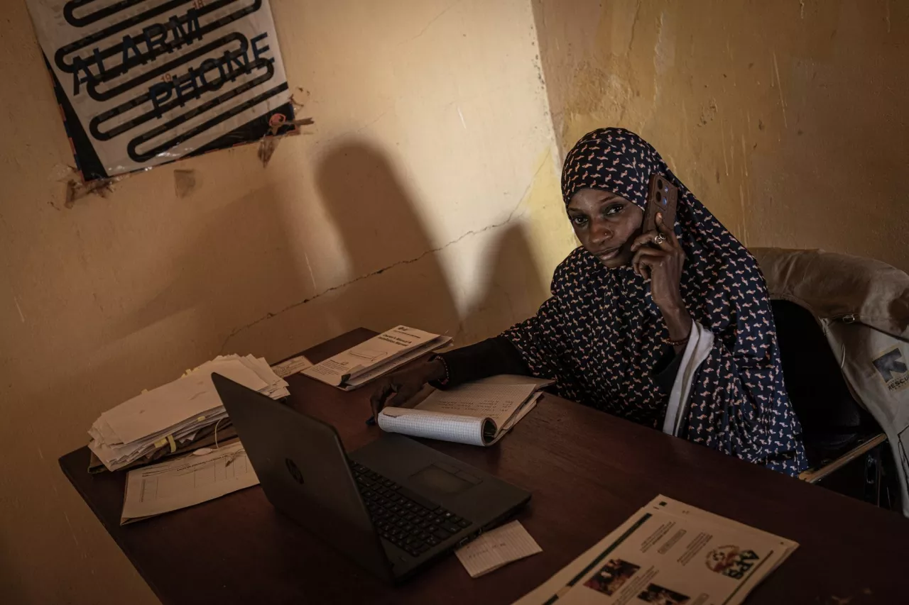 Dans un petit bureau faiblement éclairé, Bamira Hassane, une jeune femme de 23 ans, travaille pour l'ONG Alarme phone Sahara.