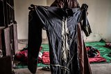 Dans une sorte de rituel, les jeunes qui ont quitté Boko Haram se détachent lentement des vêtements qu'ils portaient.