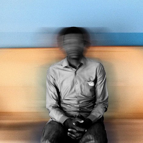 Cette image montre une personne assise sur un canapé. Le fond est flou, ce qui donne une impression de mouvement. La personne porte une chemise à rayures et a les mains posées sur ses genoux. L'atmosphère de l'image est douce grâce aux couleurs chaudes du canapé et aux nuances de bleu derrière. L'ensemble crée une sensation de calme, mais le flou ajoute une dimension de mystère.